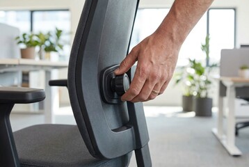 Hand adjusting lumbar support knob on ergonomic office chair backrest