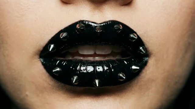 Close Up of Woman Lips with Black Glossy Lipstick and Metal Spikes