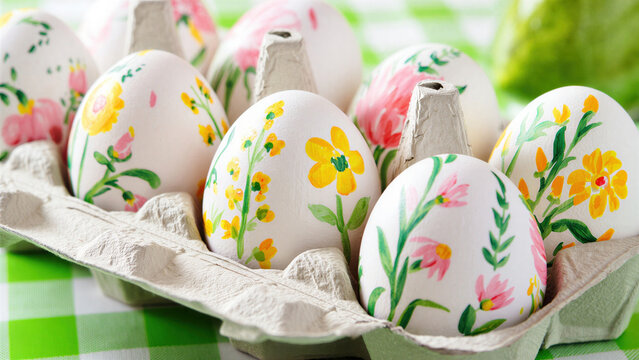 Hand painted floral easter eggs in a carton, pastel yellow pink blossoms, easter holiday table display, painted eggs tradition, easter bunny decor, easter basket, spring centerpiece, family