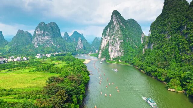 Breathtaking aerial view of the Li River winding through limestone karst mountains in Guilin, China, featuring traditional bamboo rafts and lush tropical landscape.
