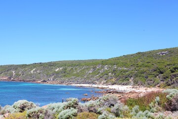 Serene coastal landscape with clear waters and lush vegetation along the shoreline. © Atikur