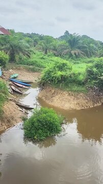 A river with brown water, polluted by environmentally damaging mining activities.