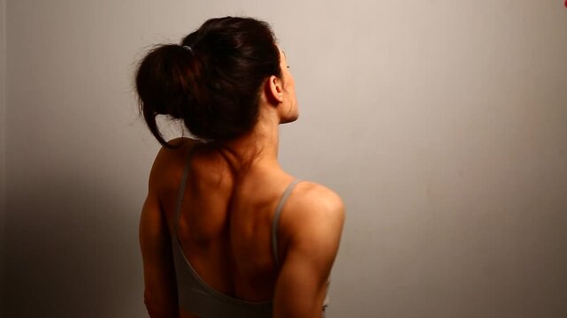 Health sport body woman doing stretching exercises for shoulders, scapula and healthy back, fitness body lifestyle. Fit naked muscles model in bra on isolated studio light with copy space. Back view