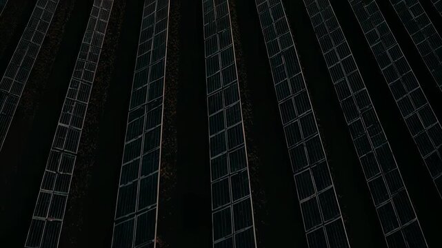 Cinematic drone orbit around a massive solar farm during golden hour, panels reflecting warm sunlight