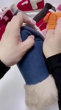 Close-up timelapse of an artisan skillfully hand-sewing traditional warm blue cotton slippers, highlighting the intricate needlework and craftsmanship in China.