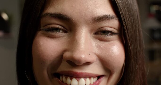 African American woman smiling and blinking during steady close-up for camera, showing nose stud