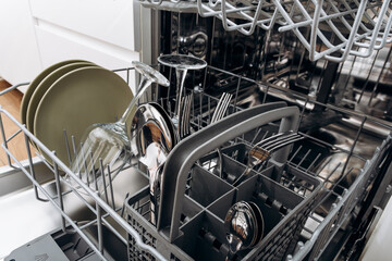 Open Dishwasher Loaded With Plates, Glasses and Cutlery in Modern Kitchen Ready to Clean