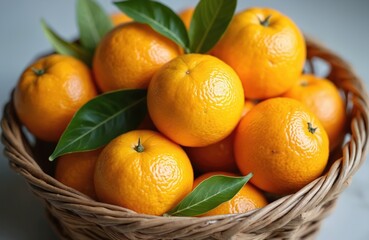 Wicker basket brimming with fresh yuzu oranges and green leaves. These citrus fruits are bright yellow orange, suggesting natural goodness and vibrant flavor for cooking or juice.