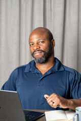 Smiling entrepreneur pointing at viewer during online business meeting