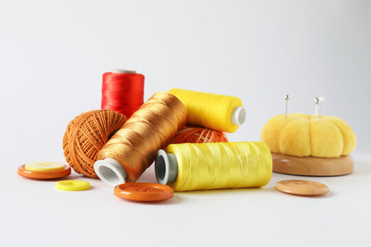 Many different sewing supplies on light grey background, closeup