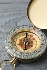 One vintage compass on grey wooden table, closeup © New Africa
