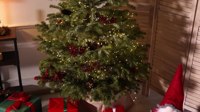 Beautiful Christmas tree and other festive decor indoors. Camera moving forward and down