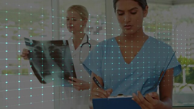 Sweeping ECG overlay clinic nurse in scrubs updating clipboard while Dr reviewing radiograph