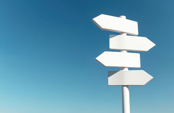 Four blank white directional signs point different ways against a clear blue sky. These empty pointers offer travelers choices for their next journey or future path.