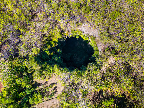 Jomblang cave in Gunungkidul is a doline formed by a cave collapse a large, natural sinkhole with steep edges surrounded by trees. Geological formations and natural land changes, drone view, aerial