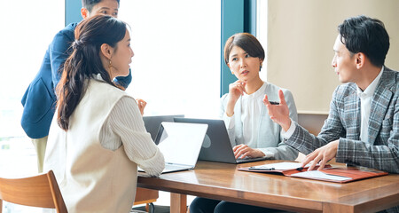 オフィスで会議するカジュアルなビジネスパーソンのグループ