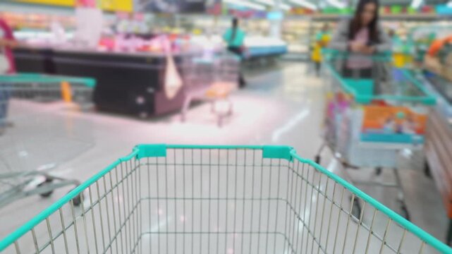 Timelapse supermarket scene from a shopping cart perspective, passing busy aisles packed with products and shoppers, representing vibrant retail commerce and daily purchasing activity.
