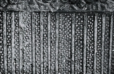 Monochrome tread pattern revealing raised circular ridges. Grippy mat surface captured in abstract vertical repetition. Industrial rubber background featuring embossed tactile forms. 