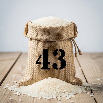 A burlap sack with rice and the number 43 on a wooden table. isolated on white background