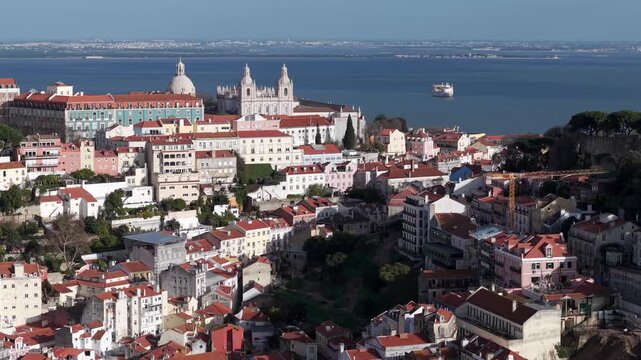 Miradouro da Graca neighbourhood on Tagus river estuary, City church and monastery, traditional Portuguese buildings with tiled roofs, Lisbon, Aerial