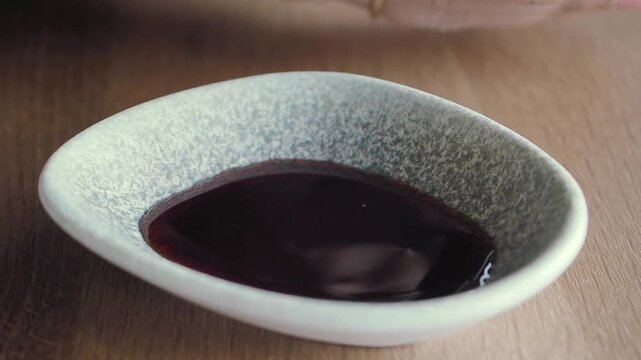 soya sauce pouring in a small container 
