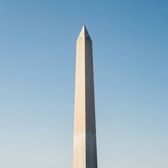 Tall, white, symmetrical obelisk rises against a seamless, clear, light blue sky. Its pointed apex is silhouetted