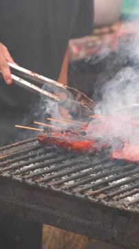 Street Vendor Grilling Marinated Chicken Barbecue Over Hot Charcoal in Manila