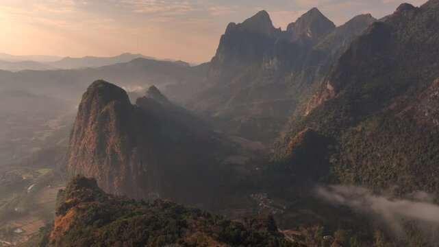 Morning mist at sunrise in Nong Khiaw, Laos. Dawn Clouds beyond Mountain Peaks, Sunrise Aerial Drone Shot.