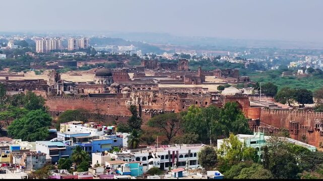 reveal shot of Gumbad Darwaza in Fort with greenery, fog, haze and buildings at old city, bidar, karnataka, india. day time, semi orbit shot, drone shot, 4k.