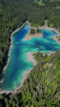 Alpine lake turquoise Caumasee Cauma in Switzerland turquoise water forest landscape aerial drone