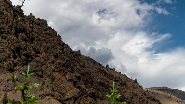 Clouds moving past a steep hillside of dark volcanic lava rock, Absaroka Range, Montana, time lapse