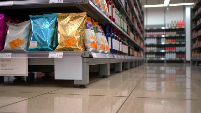 Colorful snacks in wellstocked store, Brightly lit grocery section with neat arrangements, Wellorganized supermarket corridor showcasing diverse snack options under luminous fluorescent lighting