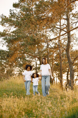 Caucasian mother and two her mixed race daughters walking in a park