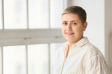Portrait of young woman with short hair near window at home