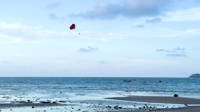 Parasailing with a Red Parachute Over the Ocean in Phuket Thailand