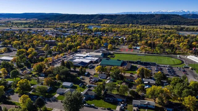 Aerial hyperlapse over the small town of Columbus, Montana in autumn with the snowy Beartooth Mountains on the horizon