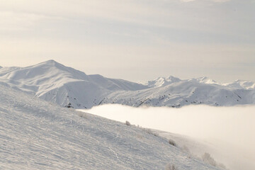 Snow covered mountain range extends into the distance under overcast sky