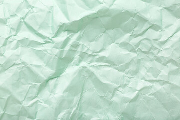 Obraz premium Green crumpled sheet of paper as background, top view