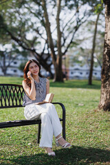 Obraz premium Young woman enjoying communicating on smartphone in park