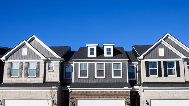 Modern residential townhouses under clear blue sky