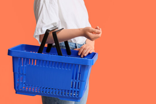 Woman with blue shopping basket on orange background