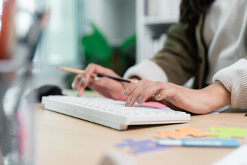 Graphic Design. Close-up of hands typing on a keyboard in a creative environment.