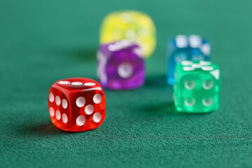 Red game dice on green background, closeup