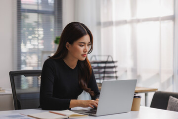 Young asian woman working with laptop in office