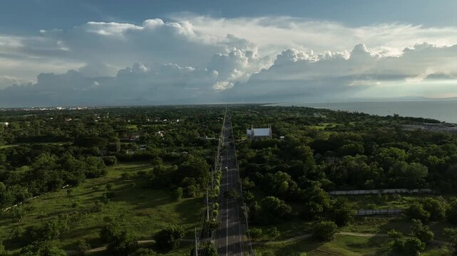 Aerial view of the scenic Bonuan Binloc highway surrounded by lush green trees and provincial landscape, Dagupan City, Pangasinan, Philippines