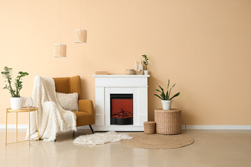Naklejka premium Fireplace, tables and armchair near beige wall in interior of room