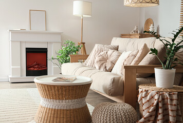Naklejka premium Cozy interior of living room with fireplace, sofa and table, closeup