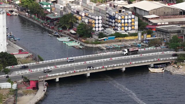 Urban traffic flowing on a bridge above a river in manila
