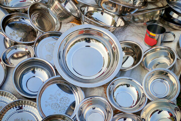 Stainless steel tableware items include plates, bowls, and mugs