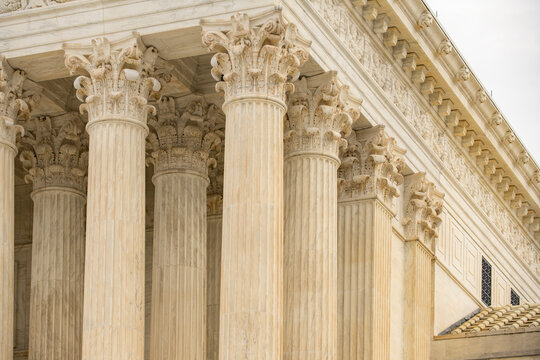 Columns marble Tall vertical facade. Columns architectural symmetry texture. Columns decorative capitals ornament Sculpture. Columns classical structure.